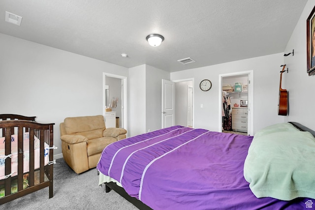 carpeted bedroom with a walk in closet, baseboards, a closet, and ensuite bathroom