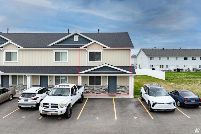 2460 W 450 N Unit 7, Tremonton, UT 84337 - view of front of property featuring uncovered parking, a shingled roof, stone siding, and a front yard