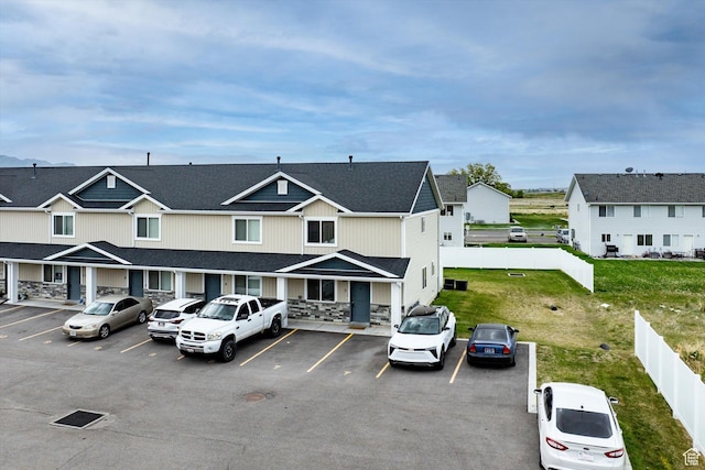 2460 W 450 N Unit 7, Tremonton, UT 84337 - view of front of house with uncovered parking, stone siding, fence, and a residential view