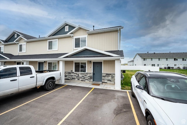 2460 W 450 N Unit 7, Tremonton, UT 84337 - view of front of house featuring uncovered parking, fence, and stone siding