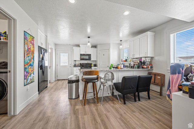 2460 W 450 N Unit 7, Tremonton, UT 84337 - kitchen with black microwave, electric range, stainless steel fridge with ice dispenser, a peninsula, and light wood-type flooring
