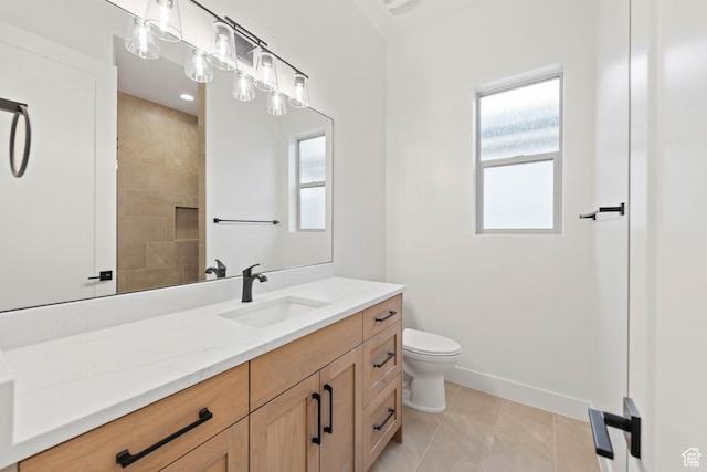 bathroom featuring vanity, toilet, baseboards, and tile patterned flooring