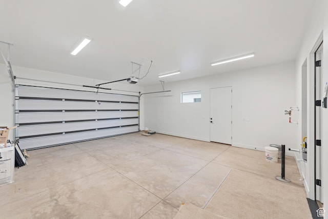 garage with a garage door opener and baseboards