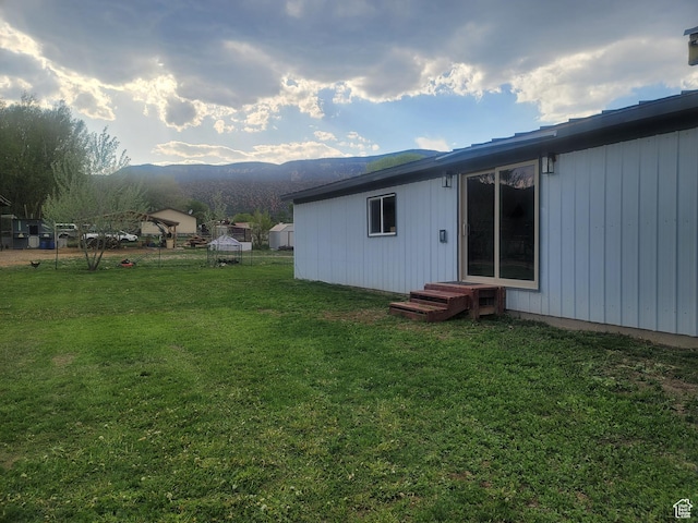 rear view of house featuring a yard, a mountain view, and entry steps