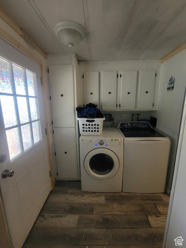 clothes washing area with cabinet space, washing machine and dryer, hardwood / wood-style flooring, and healthy amount of natural light