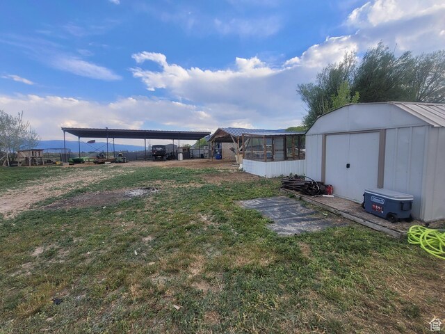 view of grassy yard with a shed and an outbuilding