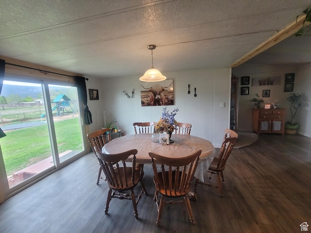 dining area with wood finished floors and a textured ceiling