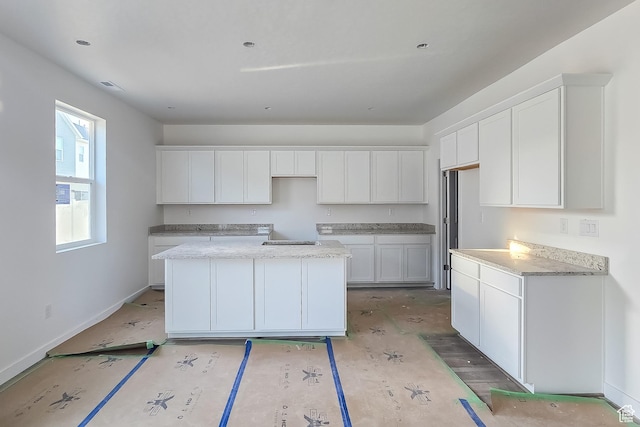 1677 N 800 W, Salem, UT 84653 - kitchen featuring a kitchen island, white cabinetry, baseboards, and light stone counters