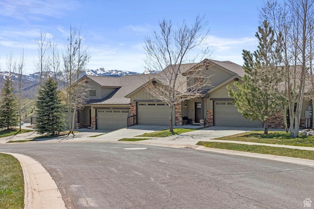 14295 N Council Fire Trl, Kamas, UT 84036 - view of front of house with concrete driveway, an attached garage, a mountain view, roof with shingles, and stone siding