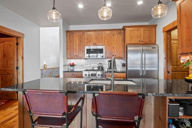 14295 N Council Fire Trl, Kamas, UT 84036 - kitchen featuring stainless steel appliances, a sink, backsplash, pendant lighting, and wood finished floors