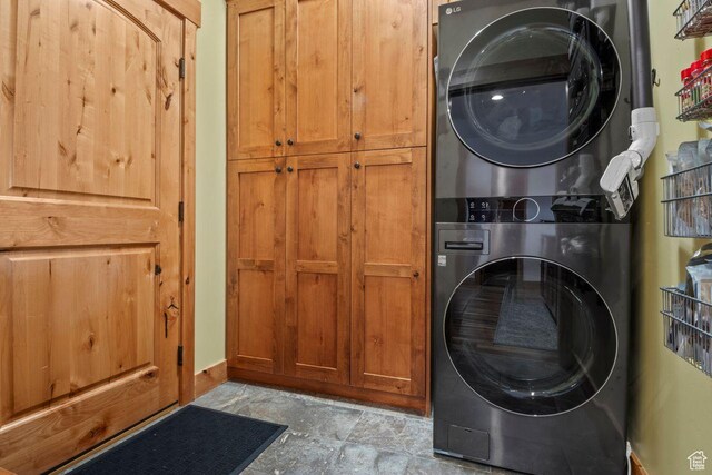 14295 N Council Fire Trl, Kamas, UT 84036 - washroom with stacked washing machine and dryer, cabinet space, and baseboards