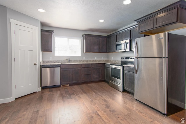 4129 W Miner Vw, Herriman, UT 84096 - kitchen featuring appliances with stainless steel finishes, dark brown cabinets, a sink, dark wood-style floors, and recessed lighting