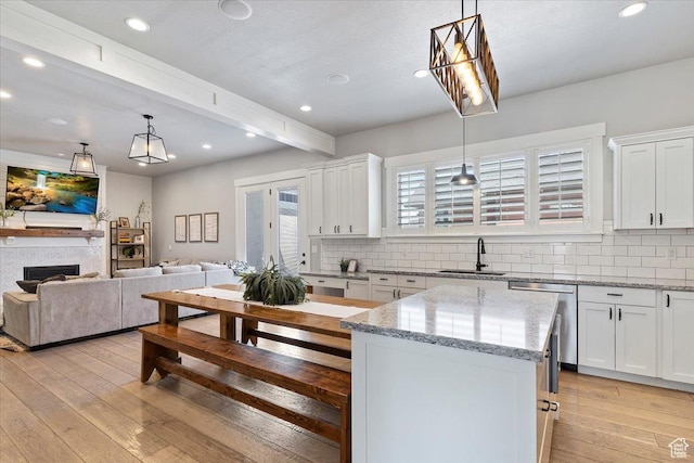 5707 Scenic Ln, Mountain Green, UT 84050 - kitchen with stainless steel dishwasher, a sink, backsplash, light wood-type flooring, and beam ceiling