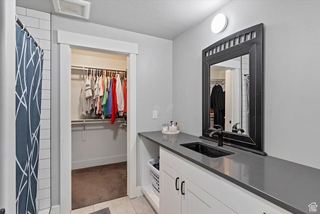 5707 Scenic Ln, Mountain Green, UT 84050 - bathroom featuring a spacious closet, vanity, tile patterned floors, baseboards, and a shower with curtain
