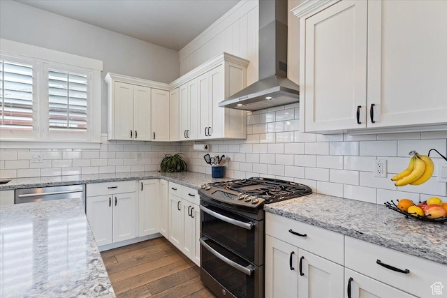 5707 Scenic Ln, Mountain Green, UT 84050 - kitchen with appliances with stainless steel finishes, wall chimney exhaust hood, wood finished floors, and white cabinets