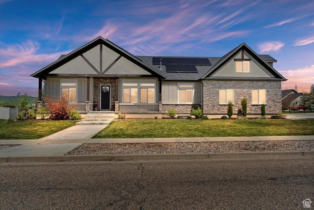 5707 Scenic Ln, Mountain Green, UT 84050 - view of front of home with stone siding, solar panels, a front lawn, and board and batten siding