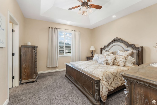 carpeted bedroom with a raised ceiling, recessed lighting, baseboards, and a ceiling fan