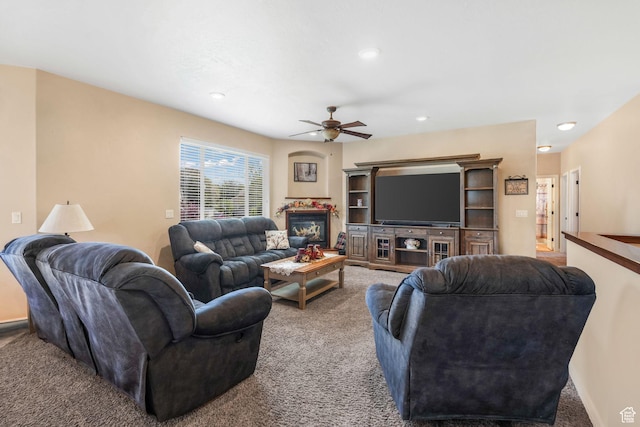 living area with carpet, a ceiling fan, recessed lighting, and a glass covered fireplace