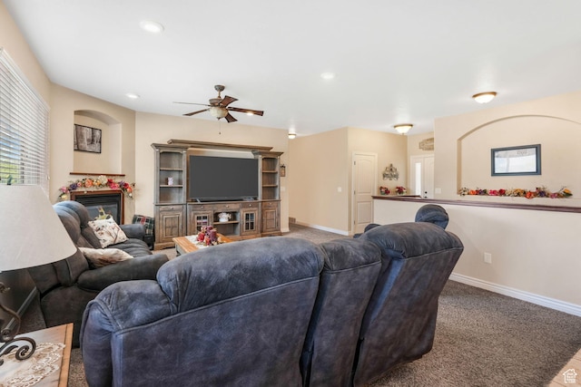 carpeted living room with a ceiling fan, baseboards, a glass covered fireplace, and recessed lighting