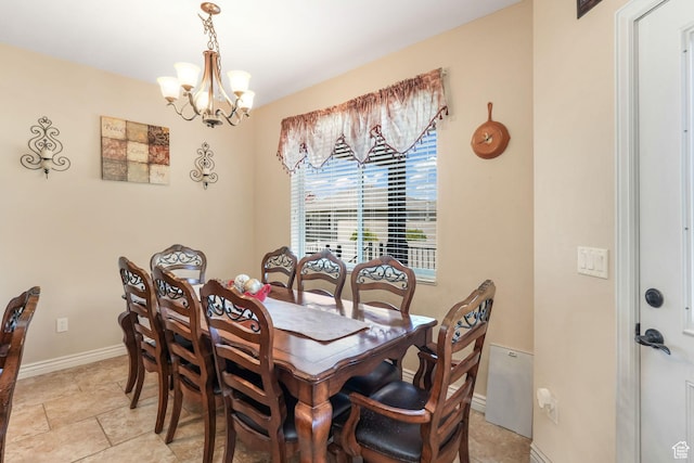 dining area featuring a chandelier and baseboards