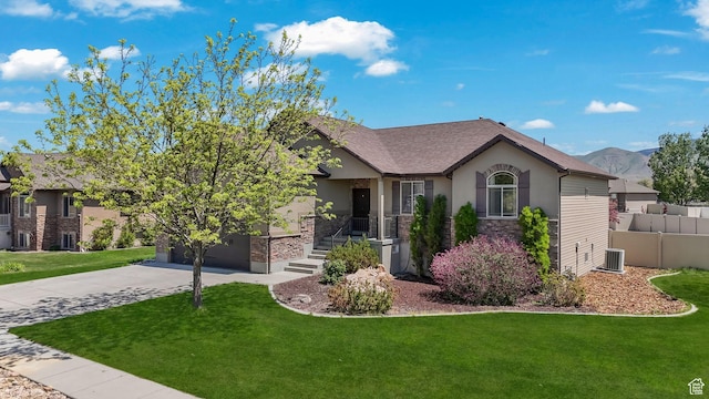 view of front of house with stucco siding, concrete driveway, a front yard, and stone siding