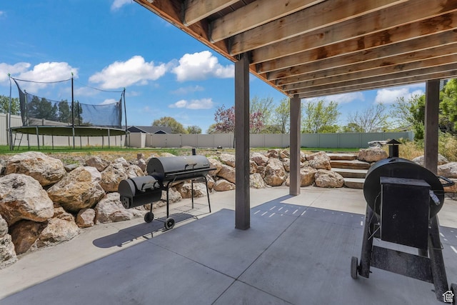 view of patio with a trampoline and a fenced backyard