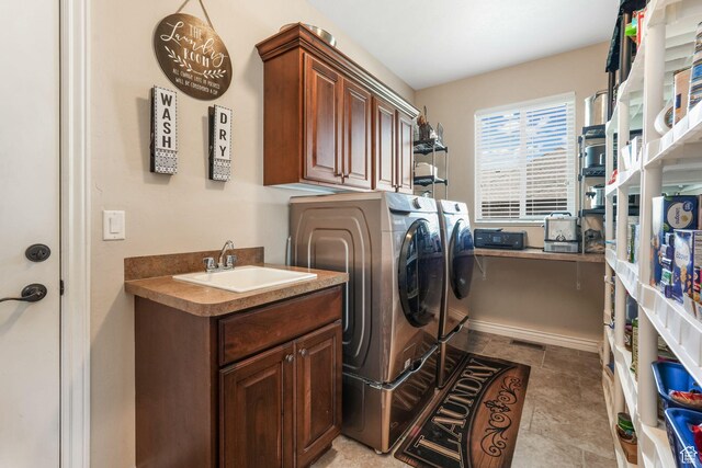 laundry room with washing machine and clothes dryer and cabinet space