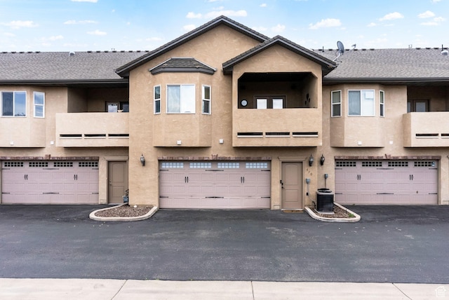 470 N Linden Ln, Providence, UT 84332 - rear view of house featuring stucco siding, a garage, central AC unit, and a balcony