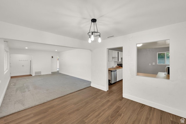 unfurnished living room with wood finished floors and baseboards