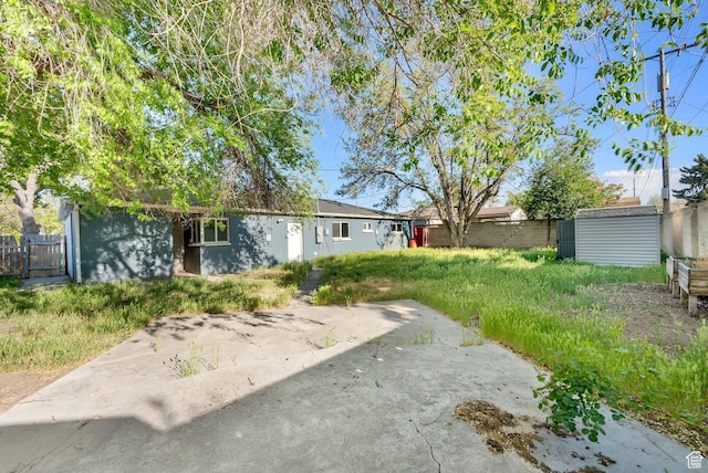 view of yard featuring fence and a patio
