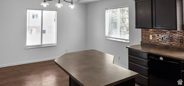 unfurnished dining area with dark wood-style flooring and baseboards