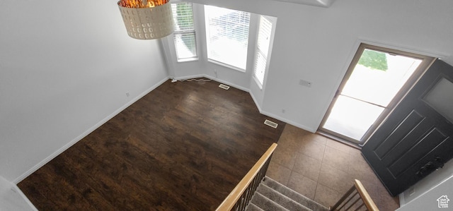 foyer with dark wood-style flooring and baseboards