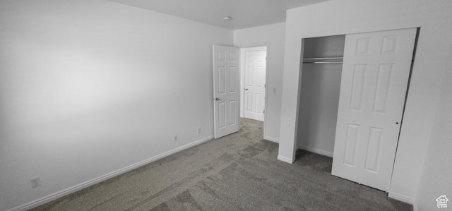 unfurnished bedroom featuring carpet floors, baseboards, and a closet