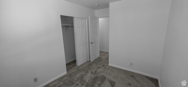 unfurnished bedroom featuring carpet floors, baseboards, and a closet