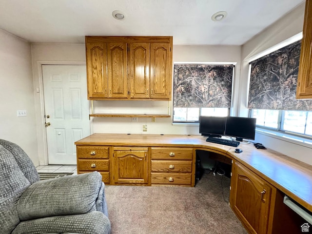 office space with healthy amount of natural light, built in study area, and light carpet