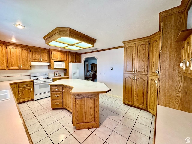 kitchen with white appliances, light tile patterned floors, light countertops, and a kitchen island