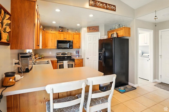 1424 W 3325 S, Perry, UT 84302 - kitchen with black appliances, a sink, washer and clothes dryer, light countertops, and a peninsula