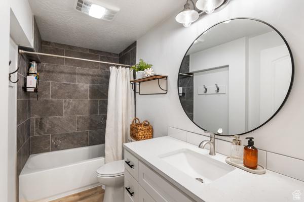 full bathroom with toilet, vanity, and shower / bath combo with shower curtain
