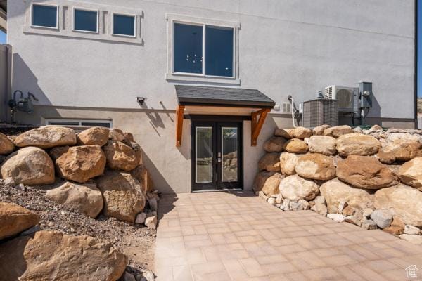 entrance to property featuring stucco siding and french doors