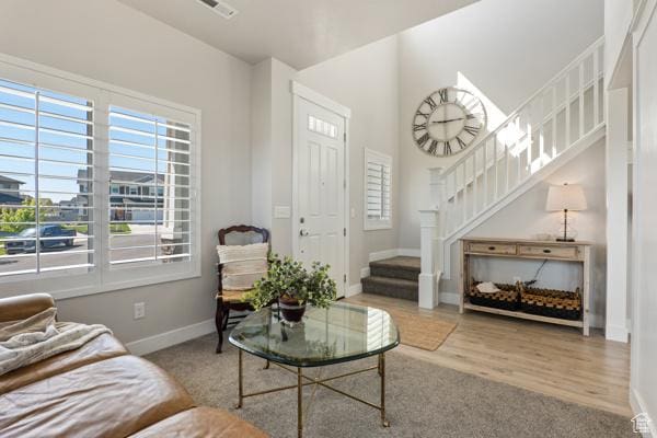 living area featuring stairway, baseboards, and wood finished floors