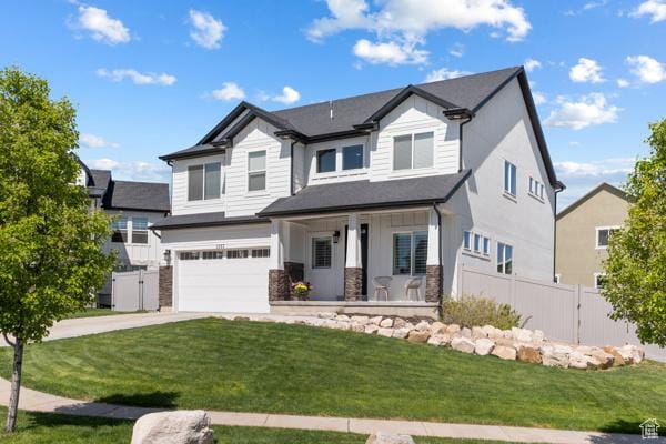 view of front of home with covered porch, concrete driveway, a garage, stone siding, and board and batten siding