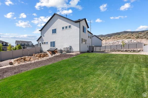 rear view of property with a mountain view and central AC