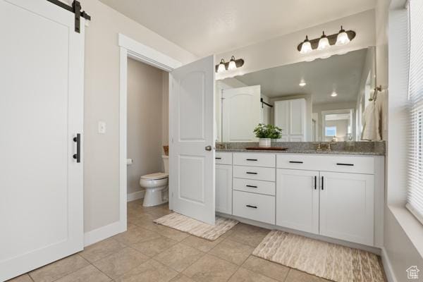 full bathroom featuring toilet, vanity, tile patterned floors, and baseboards