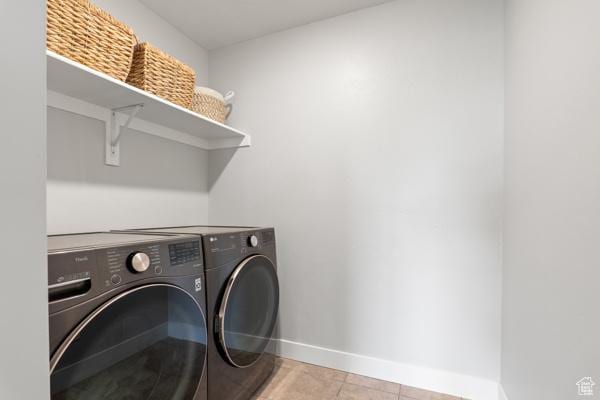 washroom with washer and clothes dryer, baseboards, and light tile patterned floors