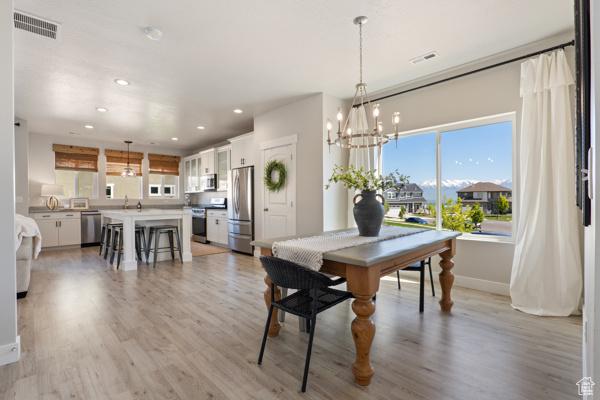 dining area with baseboards, light wood-style floors, recessed lighting, and a chandelier