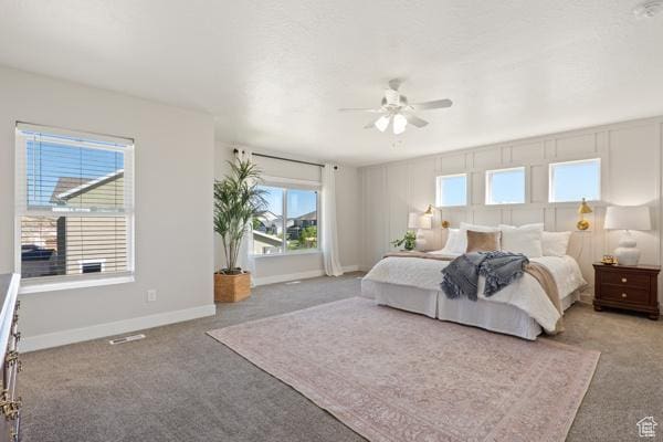 carpeted bedroom featuring baseboards and ceiling fan