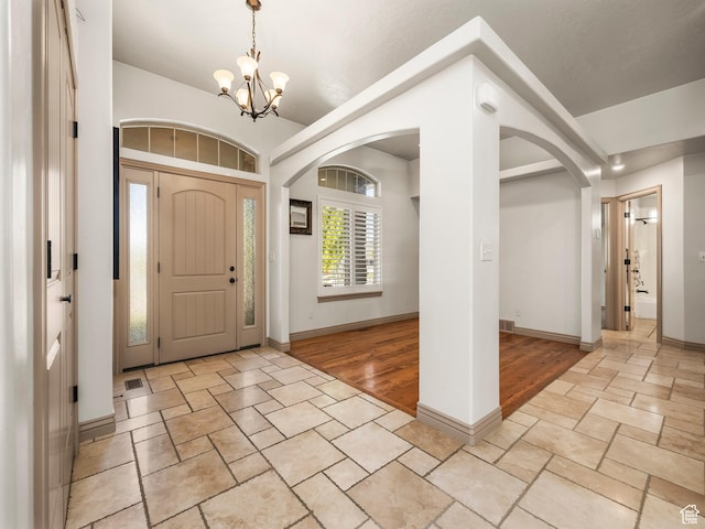 636 Quartz Dr, Santaquin, UT 84655 - foyer entrance featuring arched walkways, stone tile floors, a chandelier, and baseboards
