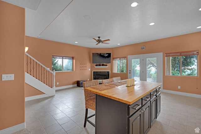 395 S 200 E, Willard, UT 84340 - kitchen with wooden counters, a glass covered fireplace, light tile patterned flooring, baseboards, and recessed lighting