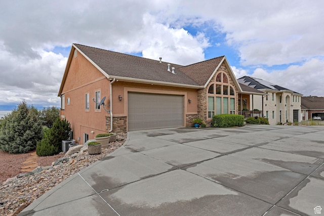 395 S 200 E, Willard, UT 84340 - view of front of property featuring stone siding, stucco siding, driveway, an attached garage, and central AC unit