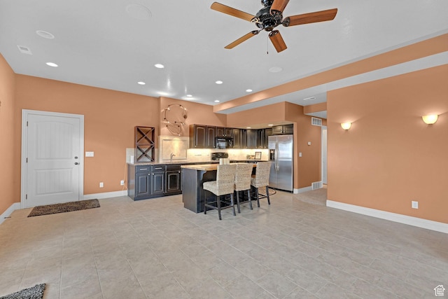 395 S 200 E, Willard, UT 84340 - kitchen featuring stainless steel refrigerator with ice dispenser, a breakfast bar area, a center island, ceiling fan, and baseboards
